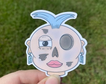 Adesivo impermeabile con testa di bambola rotta: design divertente illustrato in stile cartone animato