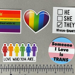 May include: A collection of six stickers featuring various pride-themed designs, including text like 'NO GENDER', 'Some men want to wear a crown Deal with it!', 'HE SHE THEY #NON-BINARY', 'GAY PRIDE LOADING...', 'LOVE WHO YOU ARE', and 'Someone I Love is TRANS'.