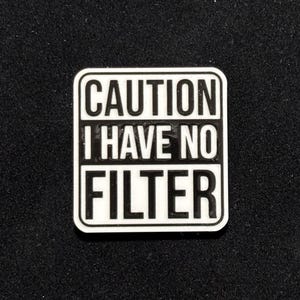 May include: White square sign with black text that reads "CAUTION I HAVE NO FILTER".