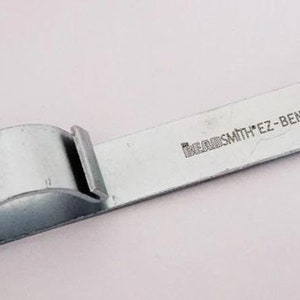 May include: A silver metal beadsmith ez-bender tool for bending wire.