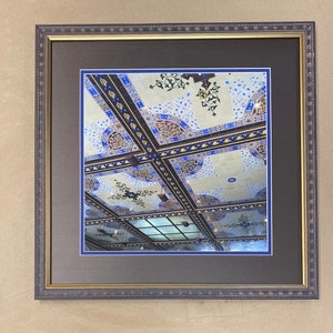 May include: A framed photograph of a ceiling with intricate blue and gold tile work. The ceiling is divided into squares with a wooden frame around each square. The tiles are decorated with floral patterns and geometric shapes.