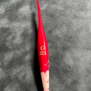 May include: A red and white crochet hook with a 4.0mm size and the brand name "Furls" printed on it.