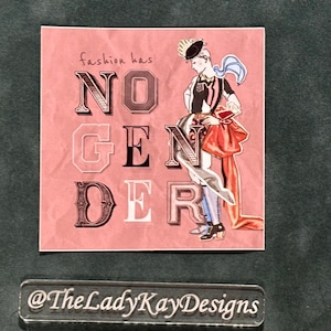 May include: A pink square print with the words "fashion has NO GENDER" in a mix of fonts. An illustration of a person in a stylish outfit is on the right. The LadyKayDesigns logo is at the bottom.