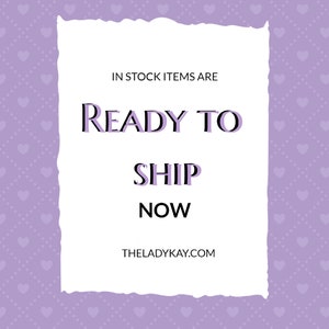 May include: A white text box with a torn edge on a purple background with a pattern of small white hearts. The text box says "IN STOCK ITEMS ARE READY TO SHIP NOW THELADYKAY.COM"