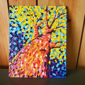 May include: A colorful abstract painting of a tree with a thick trunk and branches, painted in a pointillist style with bright yellow, orange, red, blue, and purple paint.