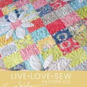 May include: A colorful quilt pattern with a patchwork design featuring a variety of floral prints. The quilt is titled "Picking Daisies" and is designed by "Keera Job" for "Live Love Sew Pattern Co."