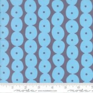 May include: A blue and gray fabric with a repeating pattern of circles. The circles are arranged in vertical rows and are slightly overlapping.