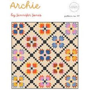 Peut inclure: Une courtepointe colorée avec un motif floral répété en bleu, orange, rose et jaune, sur un fond crème. La courtepointe est intitulée "Archie" par Jennifer Jones, modèle n° 117.