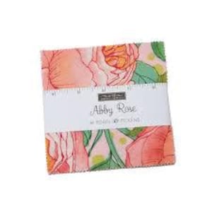 May include: A stack of fabric squares featuring a floral pattern with pink, orange, and green hues. The fabric is wrapped with a white band that reads "Abby Rose" and "by Robin Pickens."