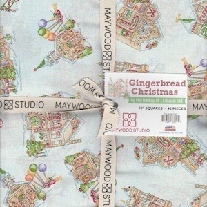 May include: A bundle of fabric squares featuring a light blue background with a repeating pattern of gingerbread houses, candy, and Christmas trees. The fabric is tied with a ribbon that reads "MAYWOOD STUDIO". The label reads "Gingerbread Christmas" by Meg Hawkey of Crabapple Hill, 10" squares, 42 pieces.
