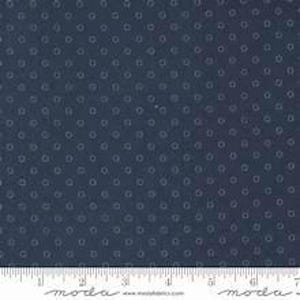 Könnte beinhalten: Ein dunkelblauer Stoff mit einem sich wiederholenden Muster aus kleinen, hellblauen kreisförmigen Umrissen. Der Stoff liegt an einem weißen Lineal an, das bis zu 18 cm misst, mit dem Text moda und moda fabrics am unteren Rand.
