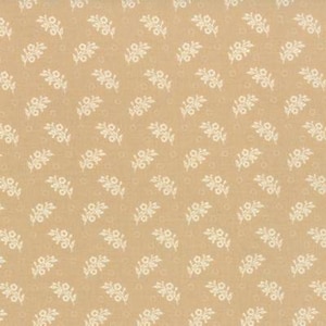 May include: A repeating pattern of small, white floral sprigs on a tan background. The design features delicate, stylized flowers and leaves, creating a vintage or cottagecore aesthetic. The fabric has a subtle texture.