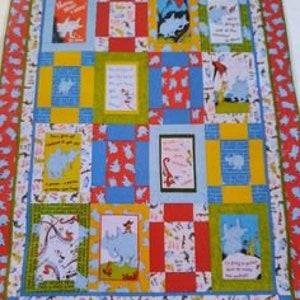 May include: A quilt featuring a patchwork design with various scenes from the children's book "Where the Wild Things Are". The quilt is made with a variety of fabrics, including red, blue, yellow, and green. The quilt is bordered with a fabric featuring a pattern of small blue and red elephants.