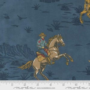 May include: Fabric with a Western theme. A cowboy on a rearing horse is depicted in a desert landscape. The fabric is primarily navy blue with tan, brown, and red accents. The word "moda" is printed at the bottom.
