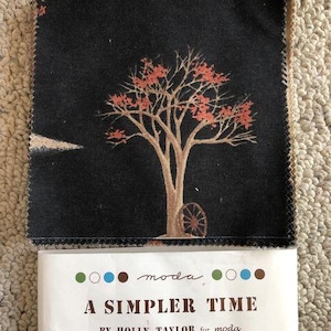 May include: A black fabric square with a printed design of a tree with red leaves. The fabric is labeled "moda" and "A Simpler Time by Holly Taylor for moda".