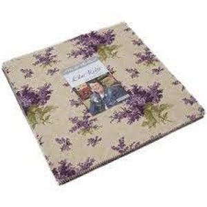 May include: A pack of 42 10-inch fabric squares featuring a floral pattern with purple and green flowers on a beige background. The fabric squares are labeled "Lilac Fields" by Moda Fabrics.