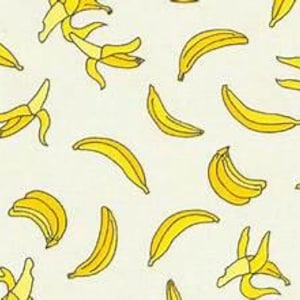 May include: A repeating pattern of bright yellow bananas on a light cream background. The design features individual bananas and small clusters, each outlined in a thin dark line, arranged in various orientations across the surface.