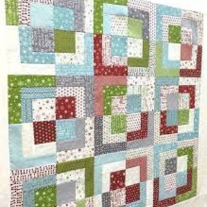 May include: A colorful quilt with a patchwork design featuring squares of red, green, blue, and white fabric.
