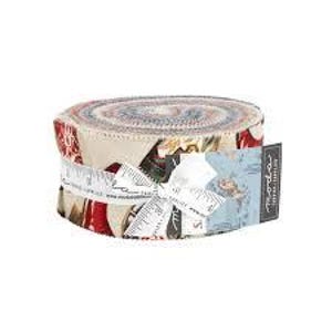 May include: A rolled fabric bundle tied with a white ribbon and a tag. The fabric features a mix of patterns in red, white, and beige. The tag has text and a small illustration. The bundle is on a white background.