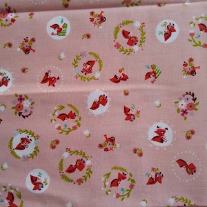 May include: Pink fabric with a repeating pattern of red foxes wearing bonnets and carrying baskets of flowers. The fabric has a white border with a repeating pattern of colorful bows.