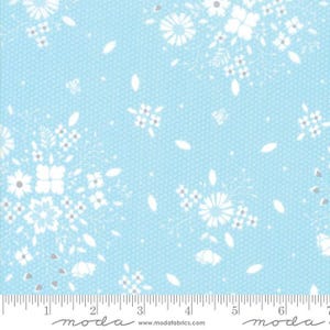 May include: Light blue fabric with a delicate floral pattern. White flowers and leaves are scattered across the surface, creating a soft, airy design. The fabric has a subtle, textured appearance, perfect for quilting or crafting projects.