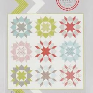 Könnte beinhalten: Ein Quiltmuster mit neun sternförmigen Blöcken in Pastellfarben: Hellblau, Rosa, Grün und Rot. Der Quilt trägt die Bezeichnung "Swoon" und misst 203 cm x 203 cm. Das Muster stammt von "Thimble Blossoms".