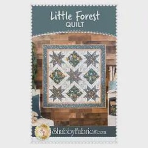 Pode incluir: Um padrão de colcha intitulado "Little Forest Quilt" com um design central de estrelas e formas de diamante em tons de verde, azul e bege. O padrão está sobre um fundo de madeira. A marca "Shabby Fabrics" é visível.