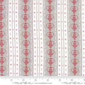 Peut inclure: Tissu rayé gris et blanc avec un motif répété de cœurs rouges et de motifs floraux.