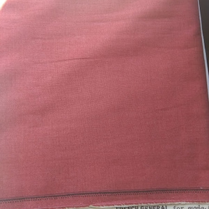 Pode incluir: Um close-up de um tecido vermelho com o texto "French General for moda" impresso na borda inferior.