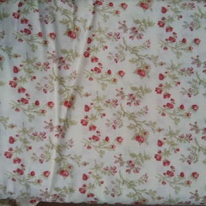 Peut inclure: Tissu blanc avec un petit motif floral rouge. Le tissu a un léger brillant et une texture douce.