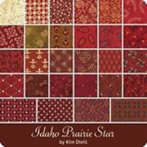 May include: A pack of 42 fabric squares in a variety of red, brown, and cream patterns. The fabric squares are arranged in a grid pattern. The text "Idaho Prairie Star" is printed on a brown label below the fabric squares.