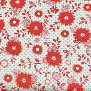 Pode incluir: Tecido floral vermelho com fundo branco e pequenas manchas azuis. O tecido apresenta um padrão repetitivo de flores vermelhas com centros brancos e folhas verdes.