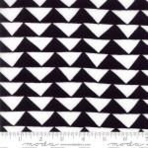May include: Black and white fabric featuring a repeating triangle pattern. The triangles alternate in colour, creating a geometric design. A ruler is printed along the bottom edge of the fabric.