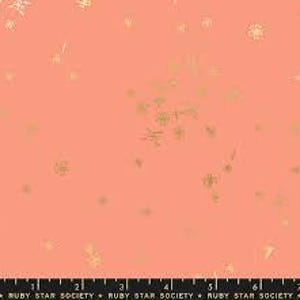 Może przedstawiać: Koralowa tkanina z rozproszonym wzorem złotych płatków śniegu i geometrycznych kształtów. Wzdłuż dolnej krawędzi znajduje się linijka w centymetrach. Tekst "RUBY STAR SOCIETY" jest wydrukowany na dole.