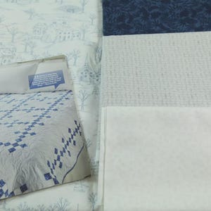 Może przedstawiać: Kolekcja próbek tkanin i wzór na kołdrę. Wzór na kołdrę ma białe tło z niebieskim wzorem w romby. Próbki tkanin obejmują niebieski nadruk w kwiaty, teksturowaną szarą tkaninę i białą tkaninę.