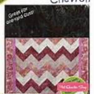 May include: A quilting pattern for a chevron quilt using the strip tube technique. The pattern features a pink, white, and burgundy chevron design with a pink border.