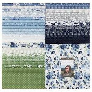 Könnte beinhalten: Ein Stapel quadratischer Stoffmuster mit einer Vielzahl von blauen, weißen und grünen Mustern, darunter Blumen-, Karomuster, Streifen und Punkte. Ein Etikett mit dem Text Moda und dem Porträt einer Person ist am vorderen Stoff befestigt.