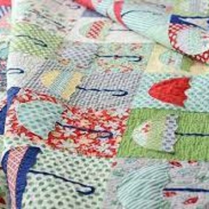 May include: A colorful patchwork quilt with a repeating pattern of umbrellas in various colors and patterns. The quilt is made with a variety of fabrics, including red, blue, green, and yellow.