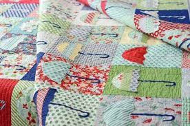 May include: A colorful patchwork quilt with a repeating pattern of umbrellas in various colors and patterns. The quilt is made with a variety of fabrics, including red, blue, green, and yellow.