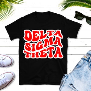 Könnte beinhalten: Schwarzes T-Shirt mit einer roten "Delta Sigma Theta" Grafik in einer Retro-Schrift.