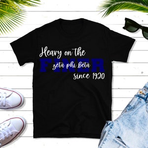 May include: Black t-shirt with white text that reads "Heavy on the Zeta Phi Beta since 1920". The text "Zeta Phi Beta" is in blue.