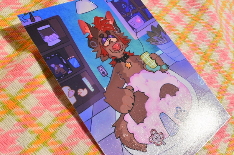 May include: An illustrated print featuring a brown anthropomorphic dog-like character in a bathroom setting. The character is holding a bar of soap over a pink, fluffy object. The background includes shelves with various items and a blue and purple color scheme.
