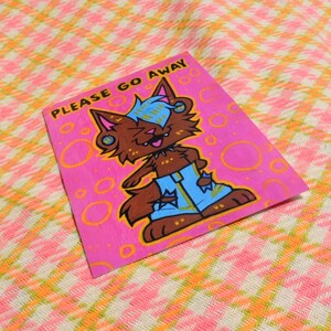 May include: A pink background with a cartoon wolf wearing blue jeans and a yellow shirt. The wolf has blue hair and is saying "PLEASE GO AWAY".