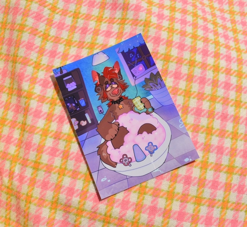 May include: A print featuring a cartoon character in a bathtub filled with pink bubbles. The character, a brown furry creature with red hair, is holding a cup. The background shows a window, a shelf with items, and a plant. The print is on a pink and yellow checkered surface.