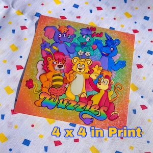 Könnte beinhalten: Ein farbenfroher Druck mit Cartoon-Tierfiguren, darunter ein Elefant, ein Hirsch und ein Löwe. Der Druck misst 10 x 10 cm und zeigt das Wort "Wuzzles" in Regenbogenfarben.