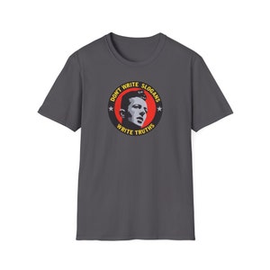 Może przedstawiać: Szary t-shirt z czerwono-żółtym kołem z grafiką. Grafika przedstawia twarz mężczyzny i napis "Don't Write Slogans Write Truths".