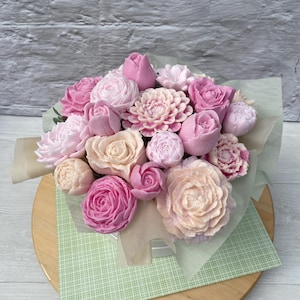 Puede incluir: Un ramo de flores de jab&oacute;n rosa y melocot&oacute;n dispuestas en una caja blanca. Las flores est&aacute;n hechas para parecer rosas, peon&iacute;as y otros tipos de flores.