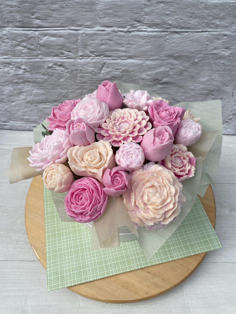 Puede incluir: Un ramo de flores de jab&oacute;n rosa y melocot&oacute;n dispuestas en una caja blanca. Las flores est&aacute;n hechas para parecer rosas, peon&iacute;as y otros tipos de flores.