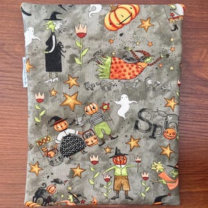 May include: Gray Halloween-themed fabric with whimsical illustrations of witches, pumpkins, ghosts, and stars. The fabric features the word "Boo" and the word "Spooky". The design is a repeating pattern of Halloween characters and elements.