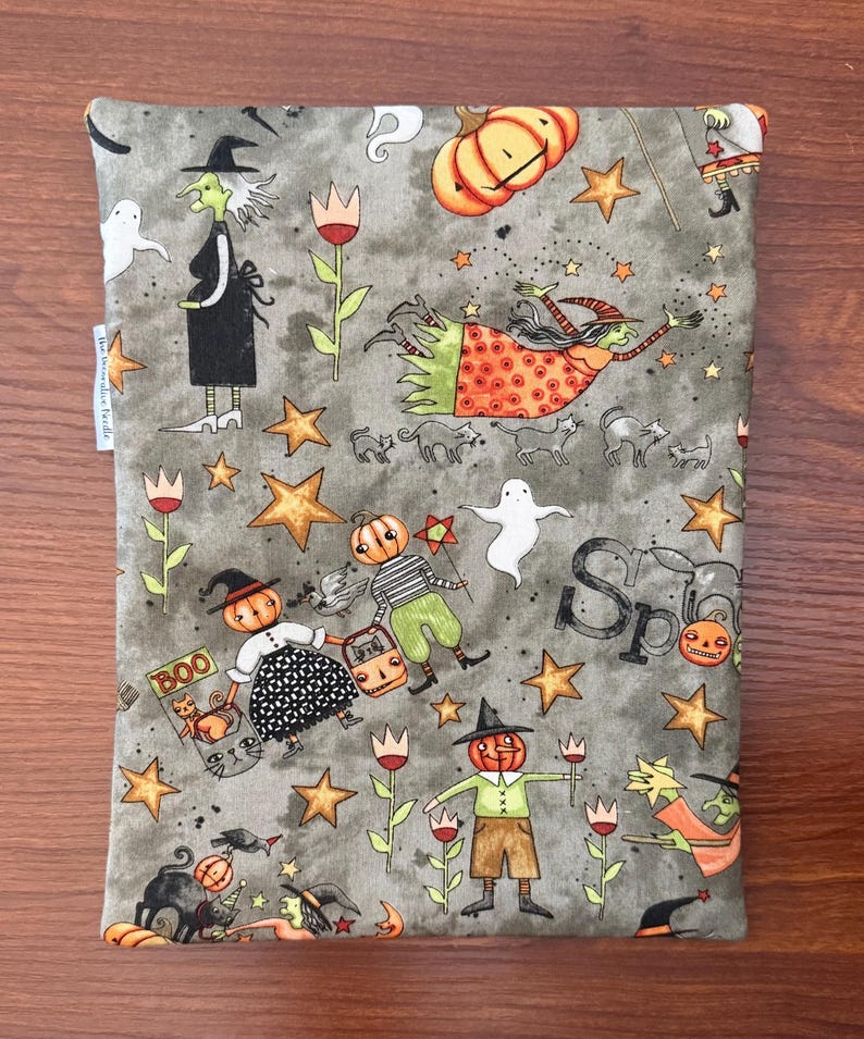 May include: Gray Halloween-themed fabric with whimsical illustrations of witches, pumpkins, ghosts, and stars. The fabric features the word "Boo" and the word "Spooky". The design is a repeating pattern of Halloween characters and elements.